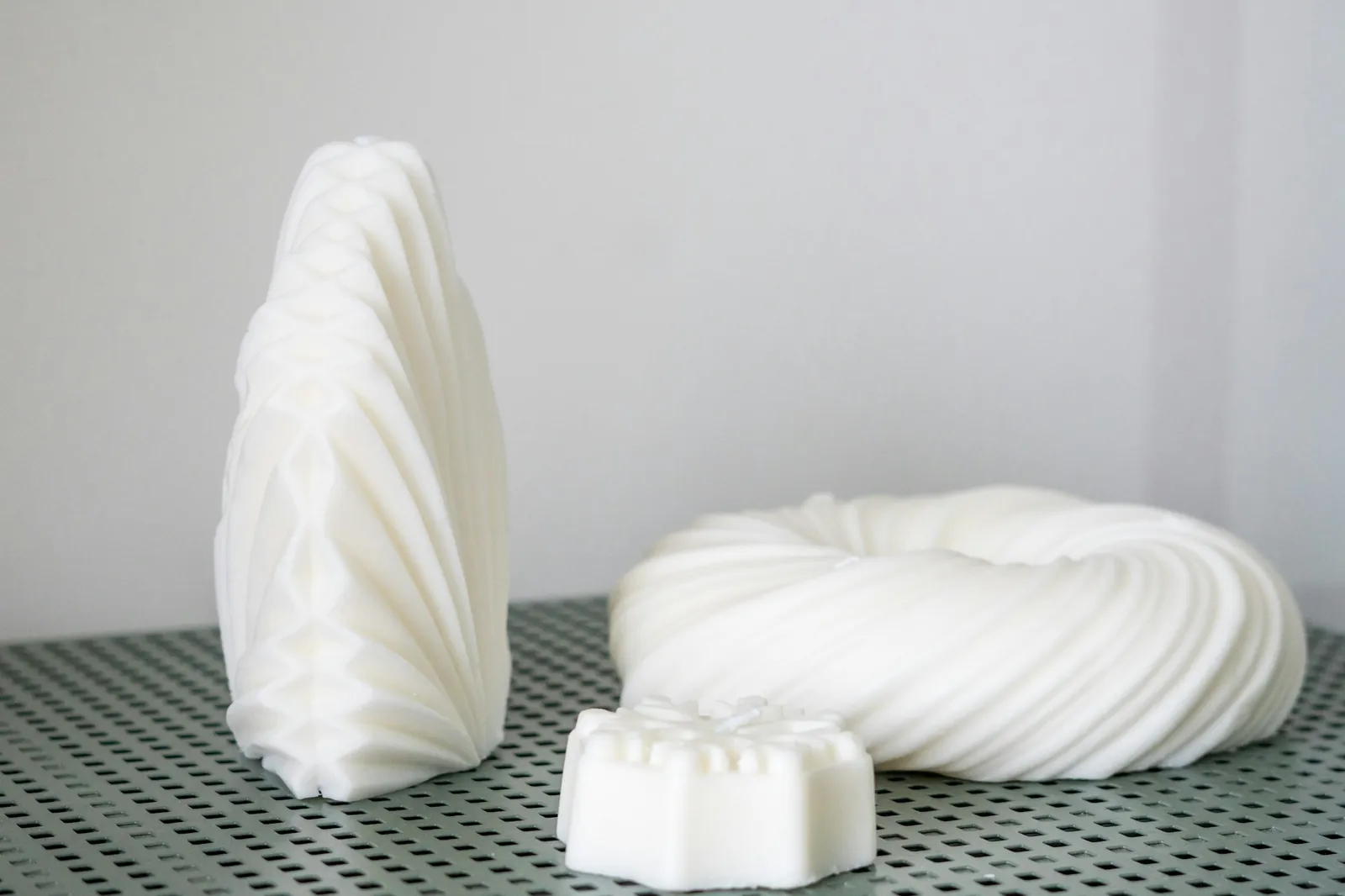 Duas esculturas brancas impressas em 3D sobre uma mesa