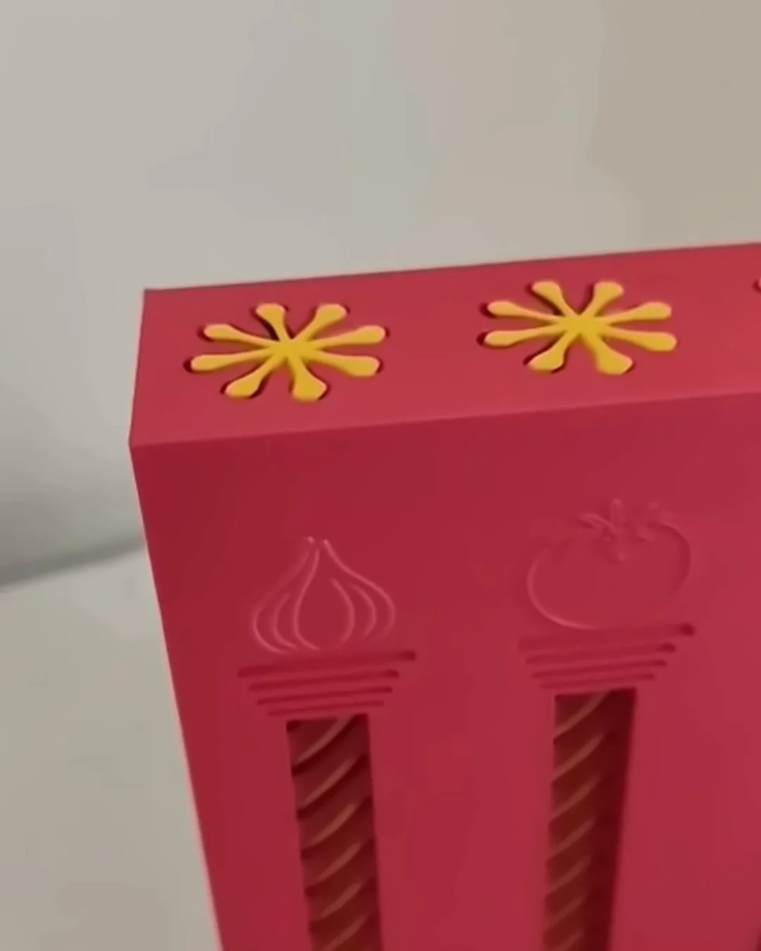 Caixa dispensadora rosa com flores amarelas no topo, impressa em 3D pela Dédalo