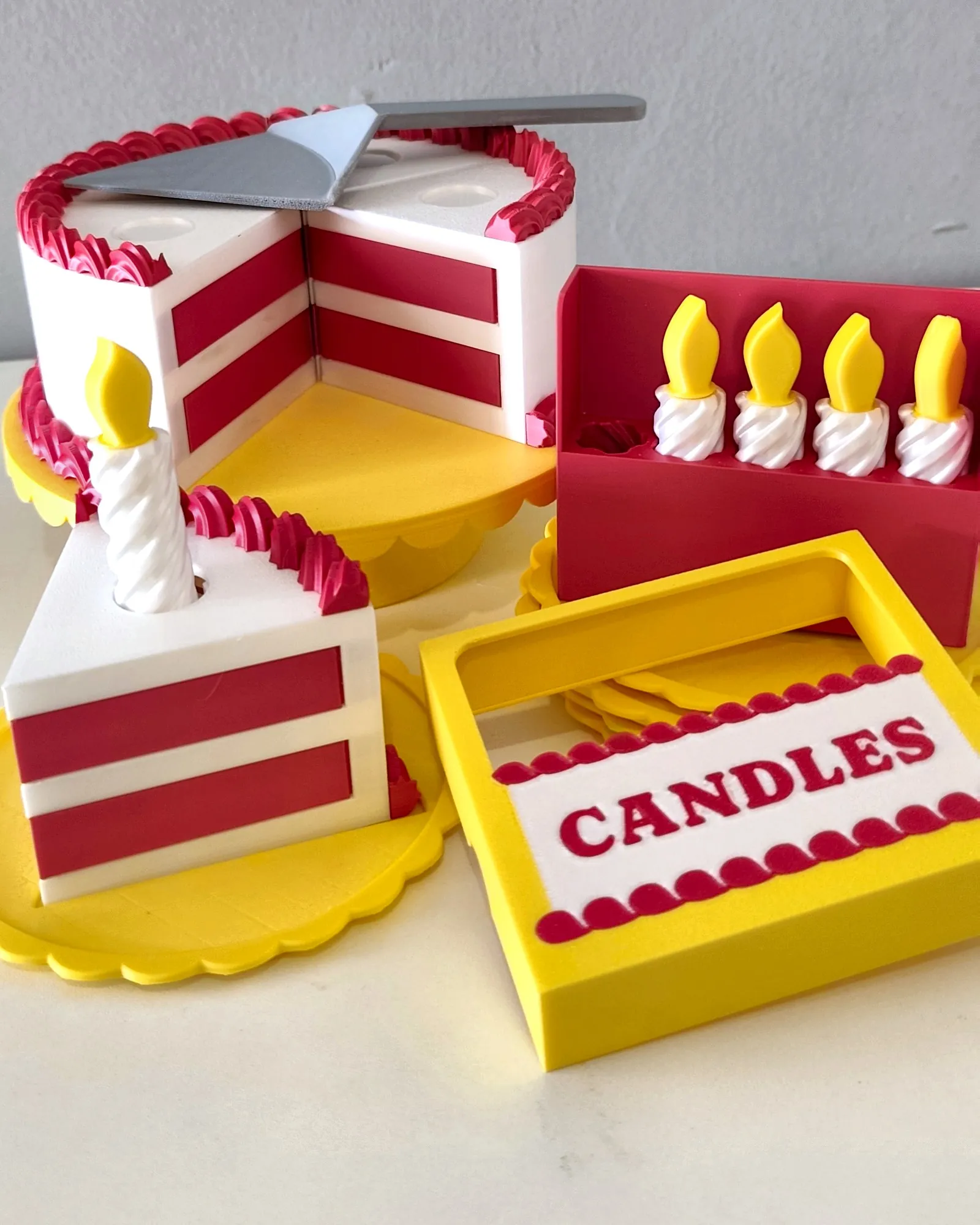 Bolo de aniversário impresso em 3D pela Dédalo, com fatia servida, velas e caixa de velas