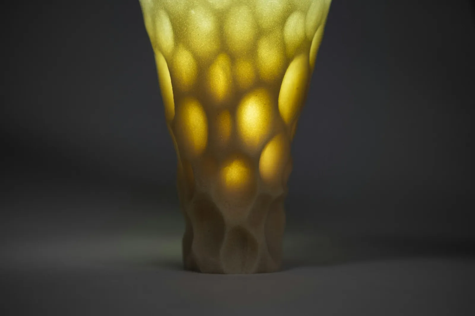 Vaso translúcido amarelo com padrão de colmeia, impresso em 3D